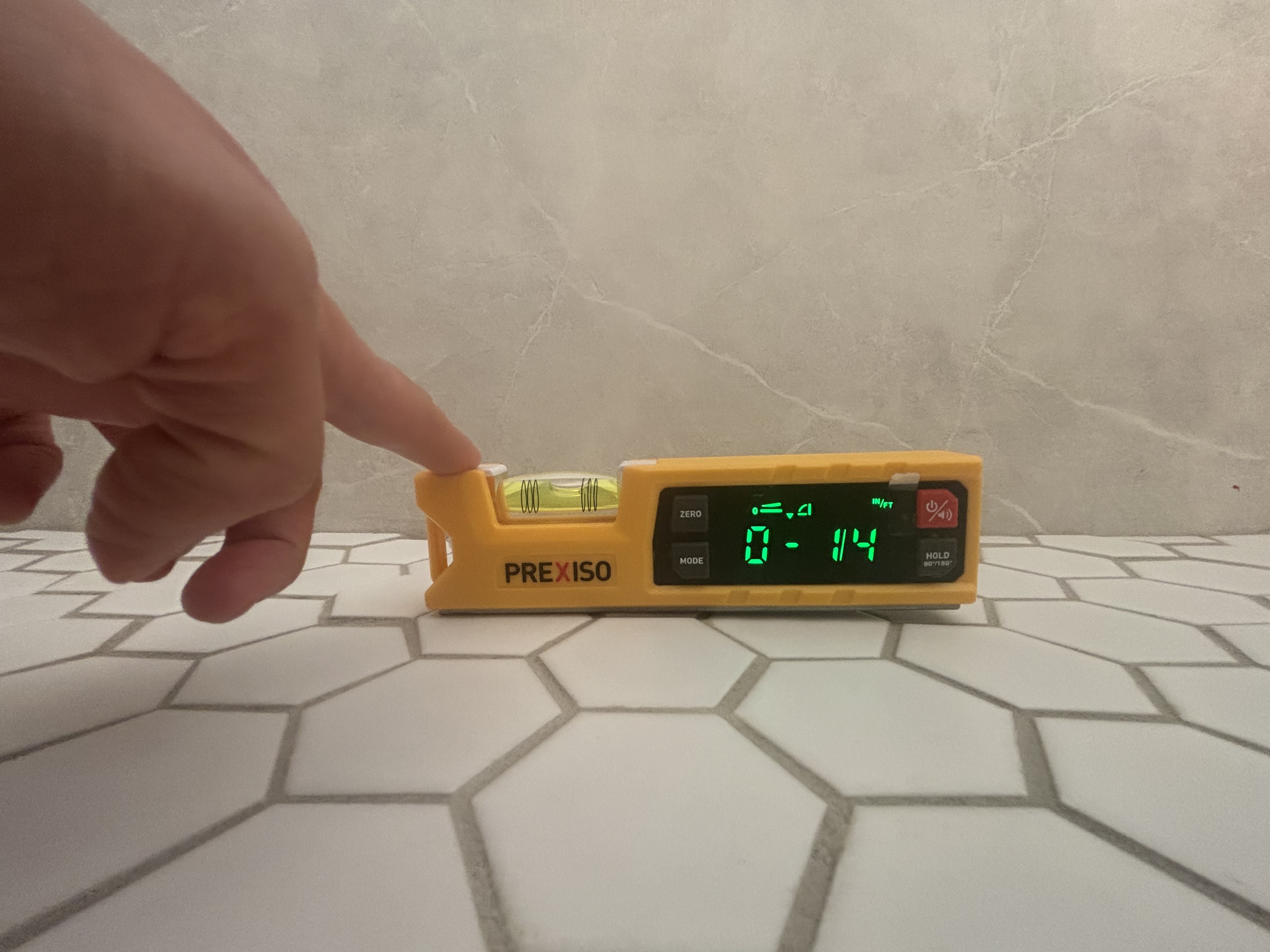 Digital level on shower floor tiles reading 0.78 degrees